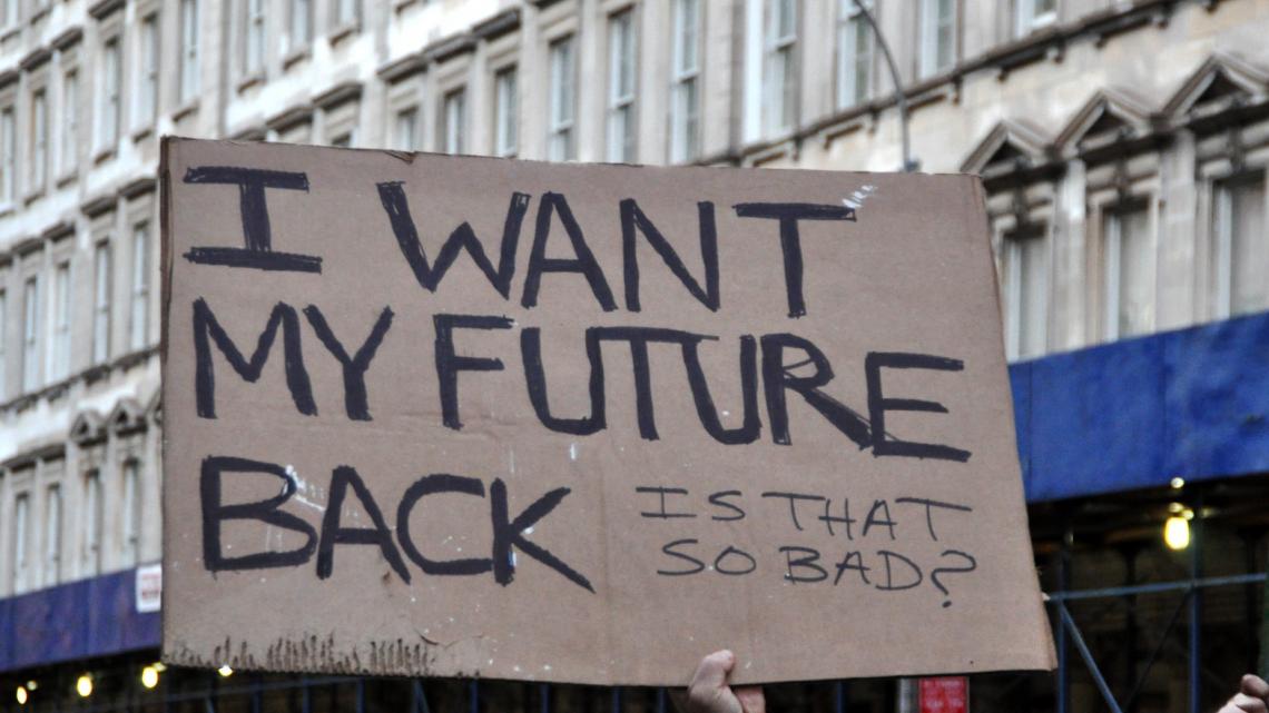 Cardboard sign: I Want my future back