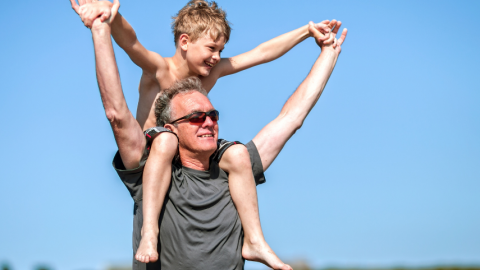 Grandpa carrying his grandson on his shoulders